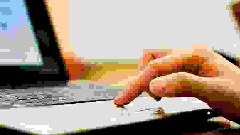 Person's Hand on the Touch Pad of a Laptop Computer