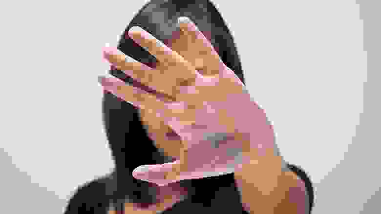 Woman Holding Up Her Hand To Block Her Face