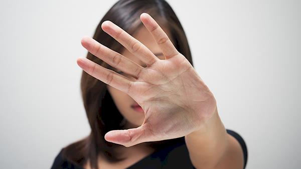 Woman Holding Up Her Hand To Block Her Face